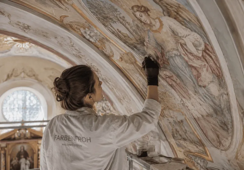 Malerin bei der Restaurierung eines Kirchenfreskos